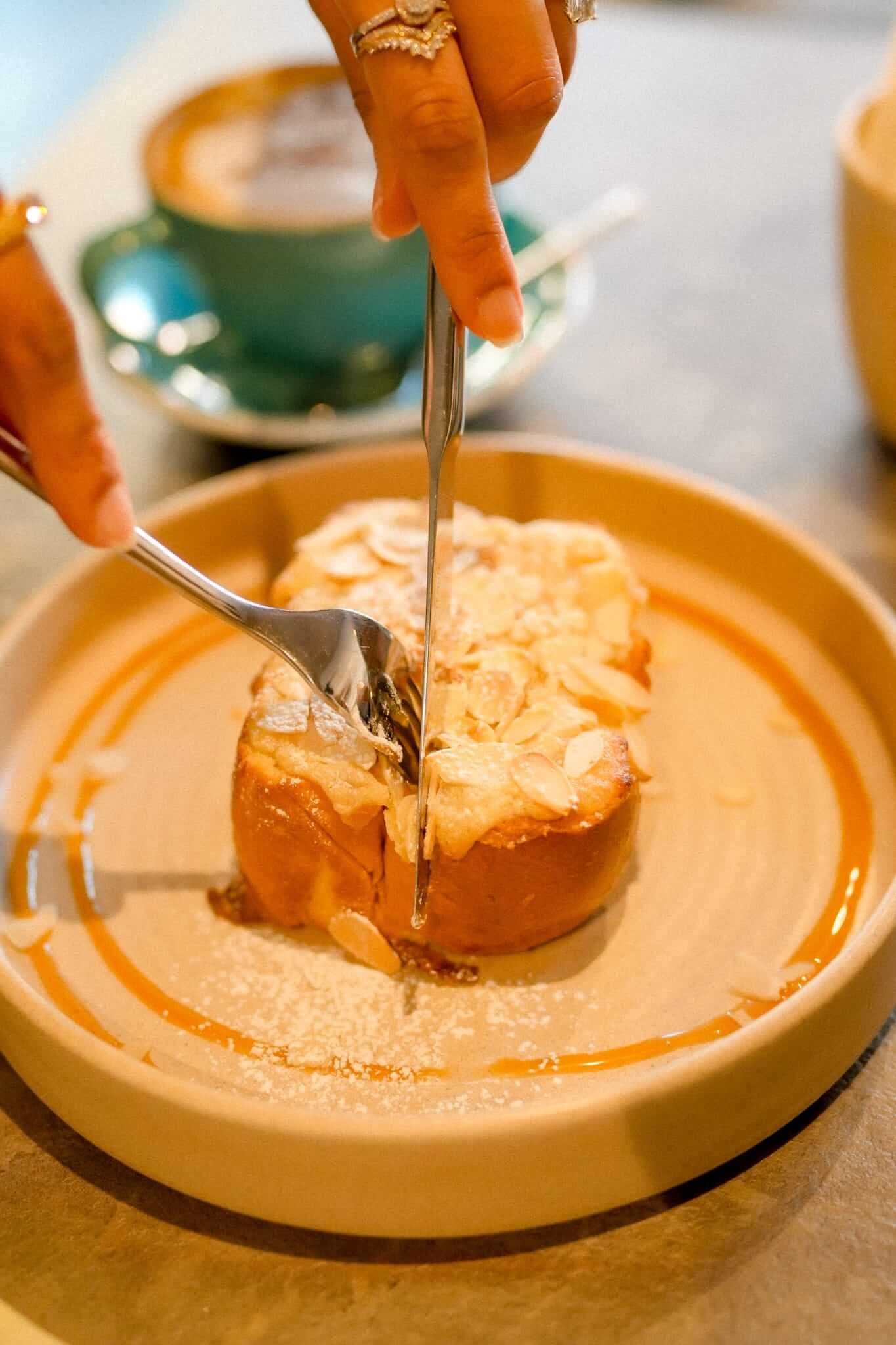 Almond croissant toast with sliced almonds and syrup drizzle at TOVE café